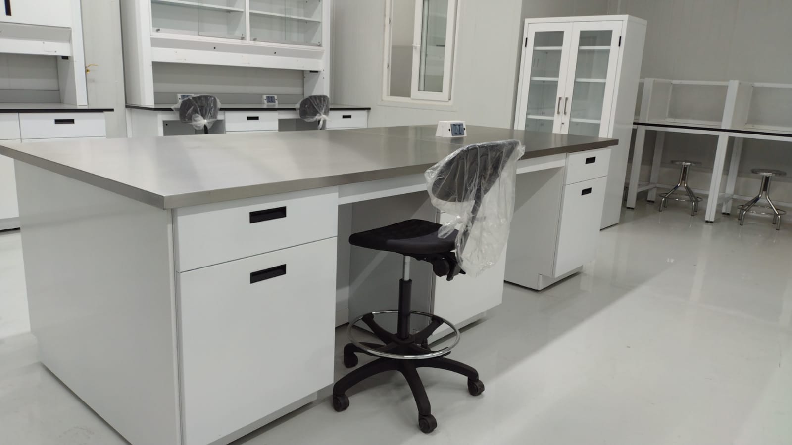 Laboratorio Golden Foods: isla central inox y línea perimetral con cabinas al fondo