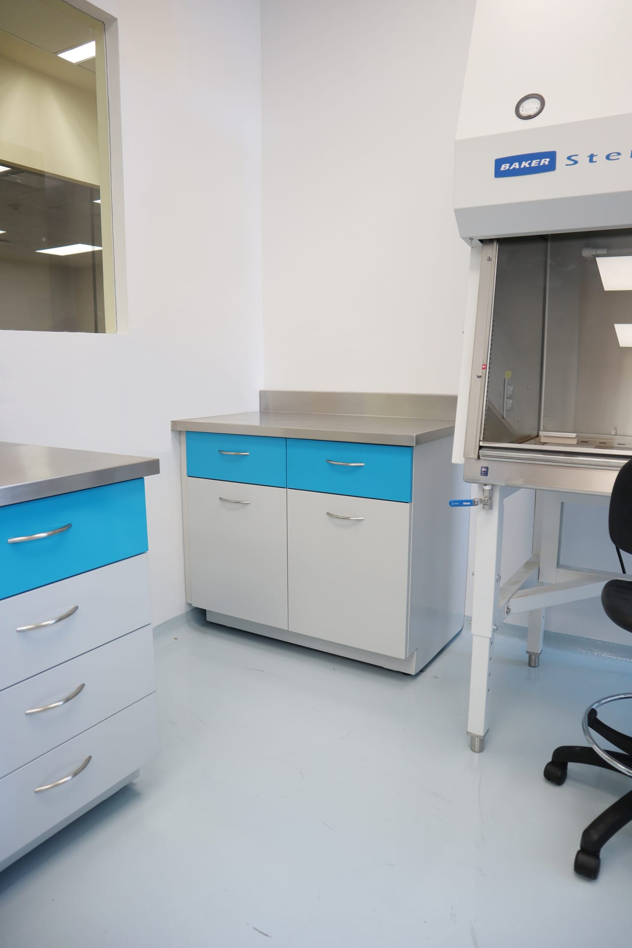 Hospital Zambrano: módulo de trabajo con cajonería azul y campana Baker SterilGARD