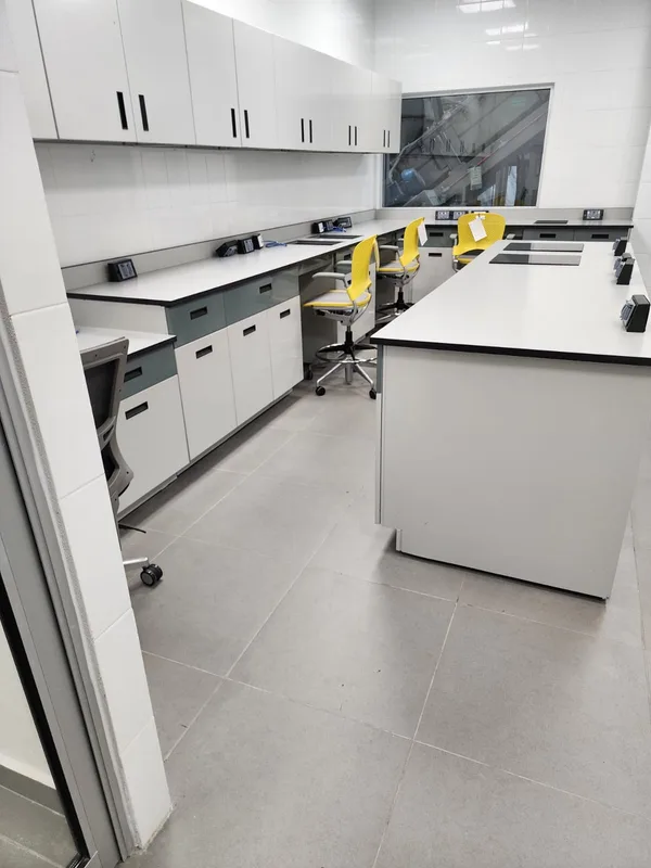 Laboratorio Alen: estación a muro con sillas ergonómicas amarillas y servicios