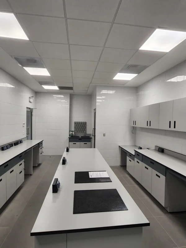 Laboratorio Alen: banco con tomas de datos, tarjas y escurridor a muro