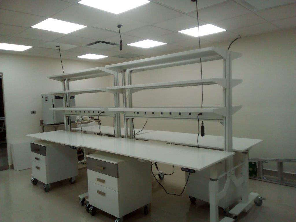 Mesas de laboratorio modulares con gabinetes rodables para análisis de alimentos.