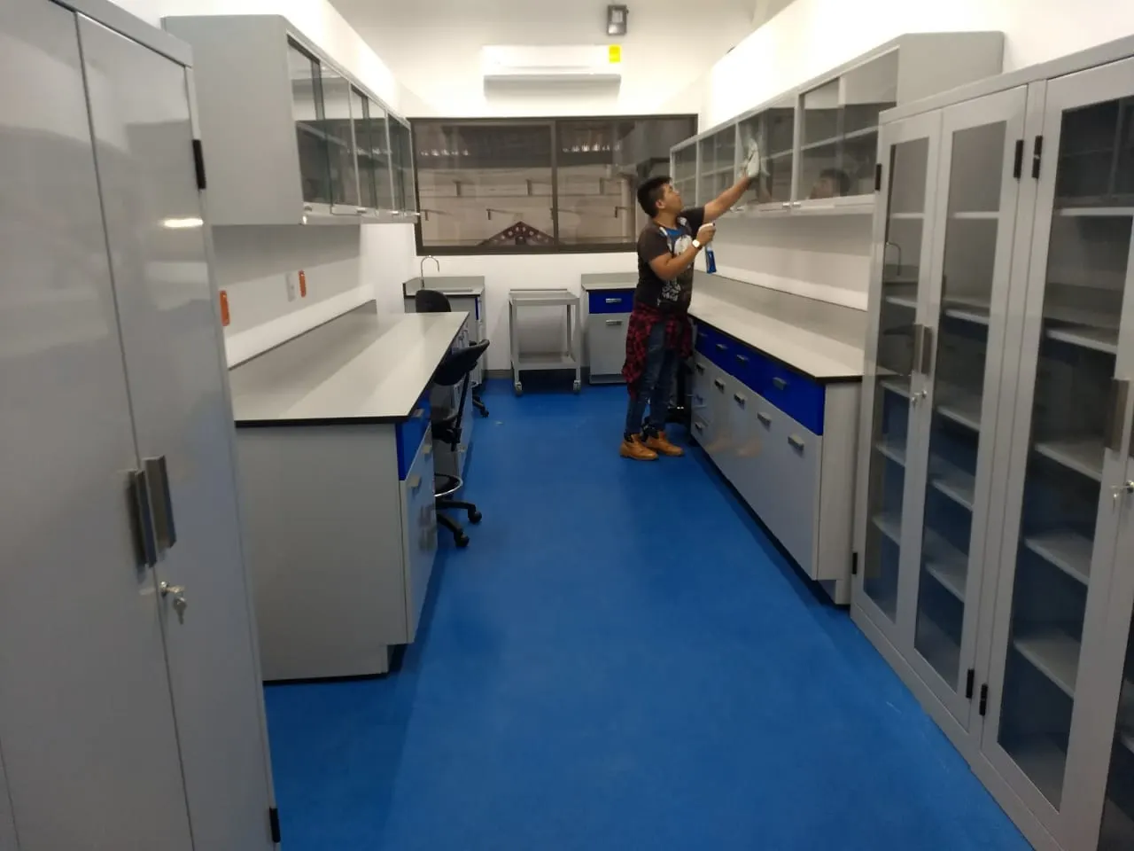Cuarto de almacenaje de laboratorio con mesas, armarios y gabinetes de reactivos