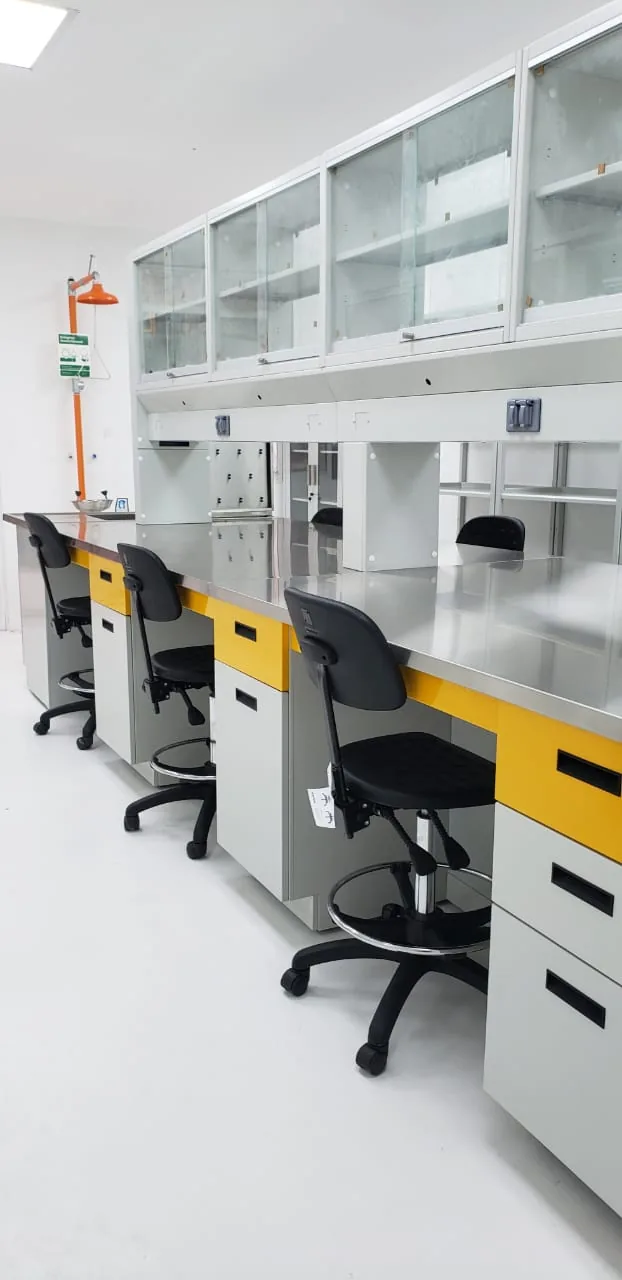 Ducha y lavaojos de emergencia instalados en laboratorio industrial con mesas de acero inoxidable