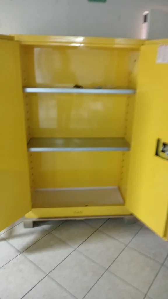 Gabinete de inflamables Justrite abierto mostrando estantes ajustables y charola de retención inferior