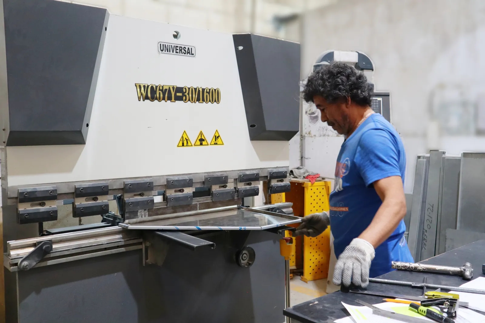Operador en plegadora CNC DURMA conformando lámina para cuerpos de gabinete.