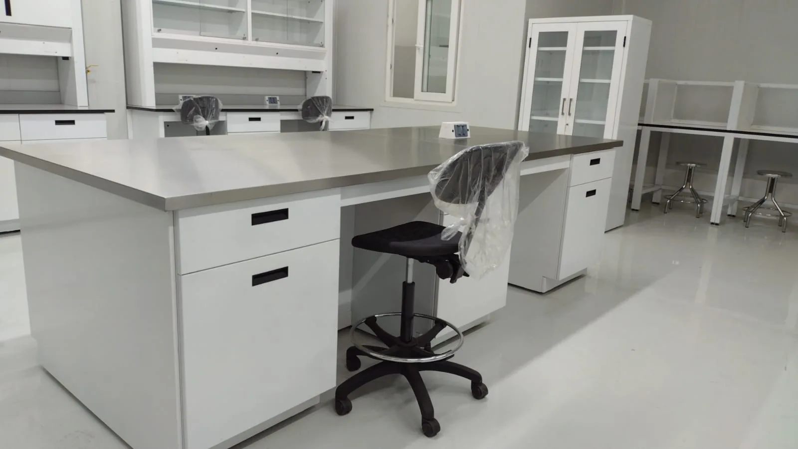 Laboratorio Golden Foods: isla central inox y línea perimetral con cabinas al fondo