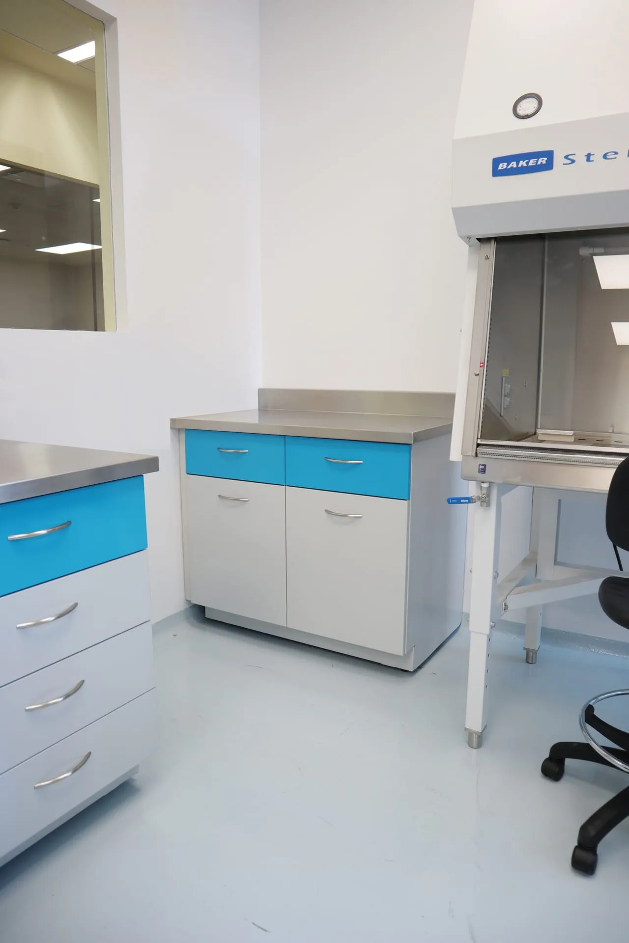 Hospital Zambrano: módulo de trabajo con cajonería azul y campana Baker SterilGARD